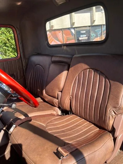 A 1949 GMC Cabover full custom brown leather interior including a full bench seat, custom headliner and rear wall panel, door panels, and new brown seat belts.