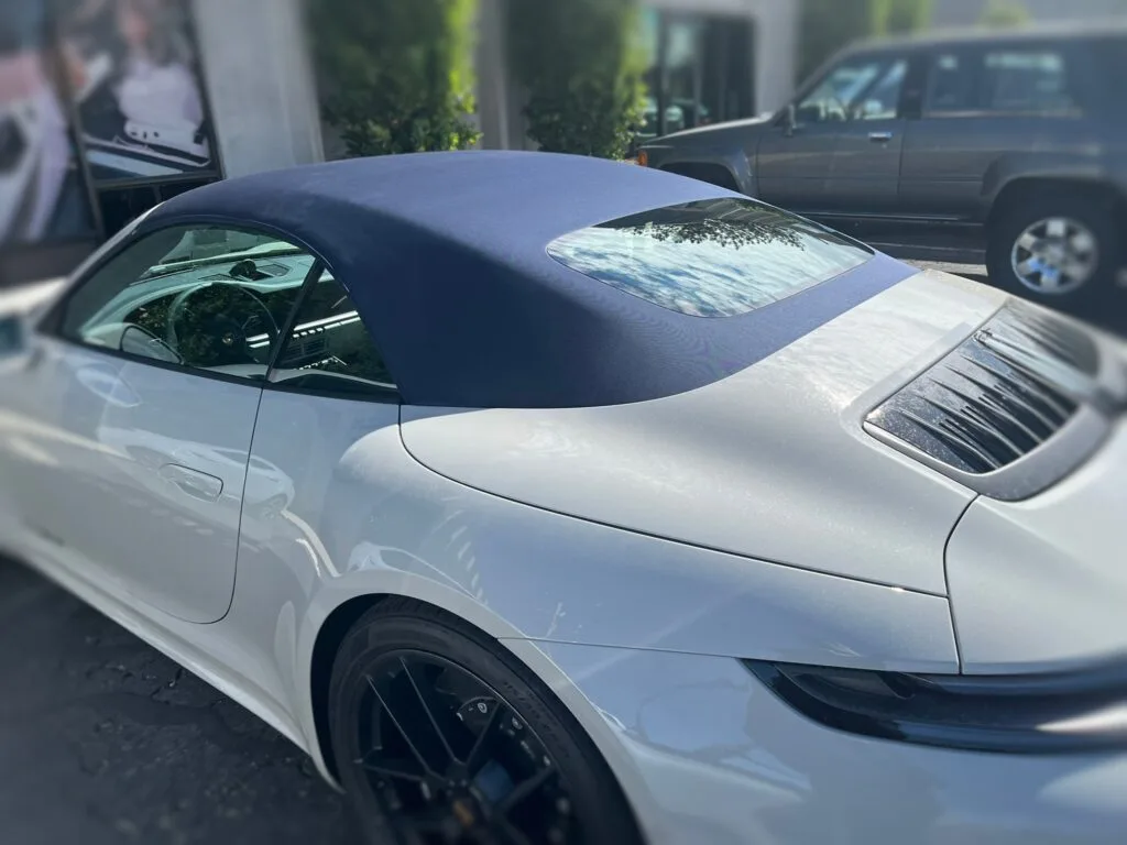 A picture of a 2022 Porsche 911 with a new navy blue convertible soft top installed. 